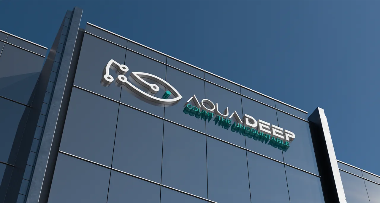 Aquadeep fish symbol and wordmark mounted on the corner of a glass building