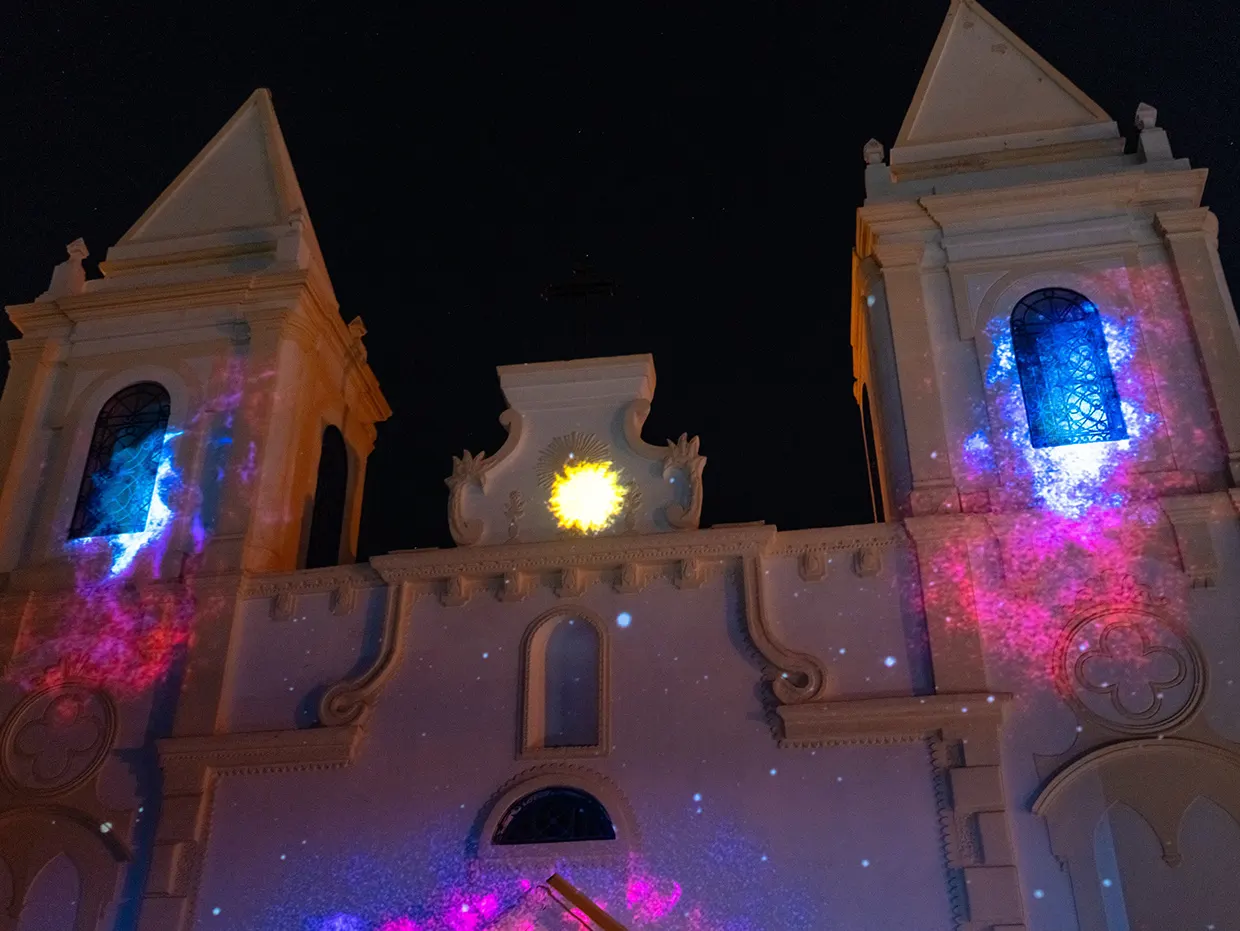 Church bell towers at night with a bright sun projected between them
